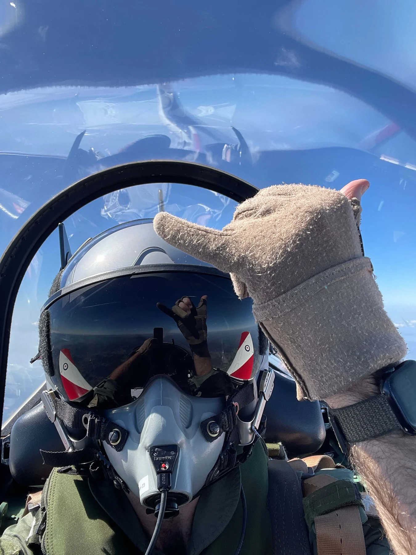 A helmeted pilot in the PC-9 cockpit