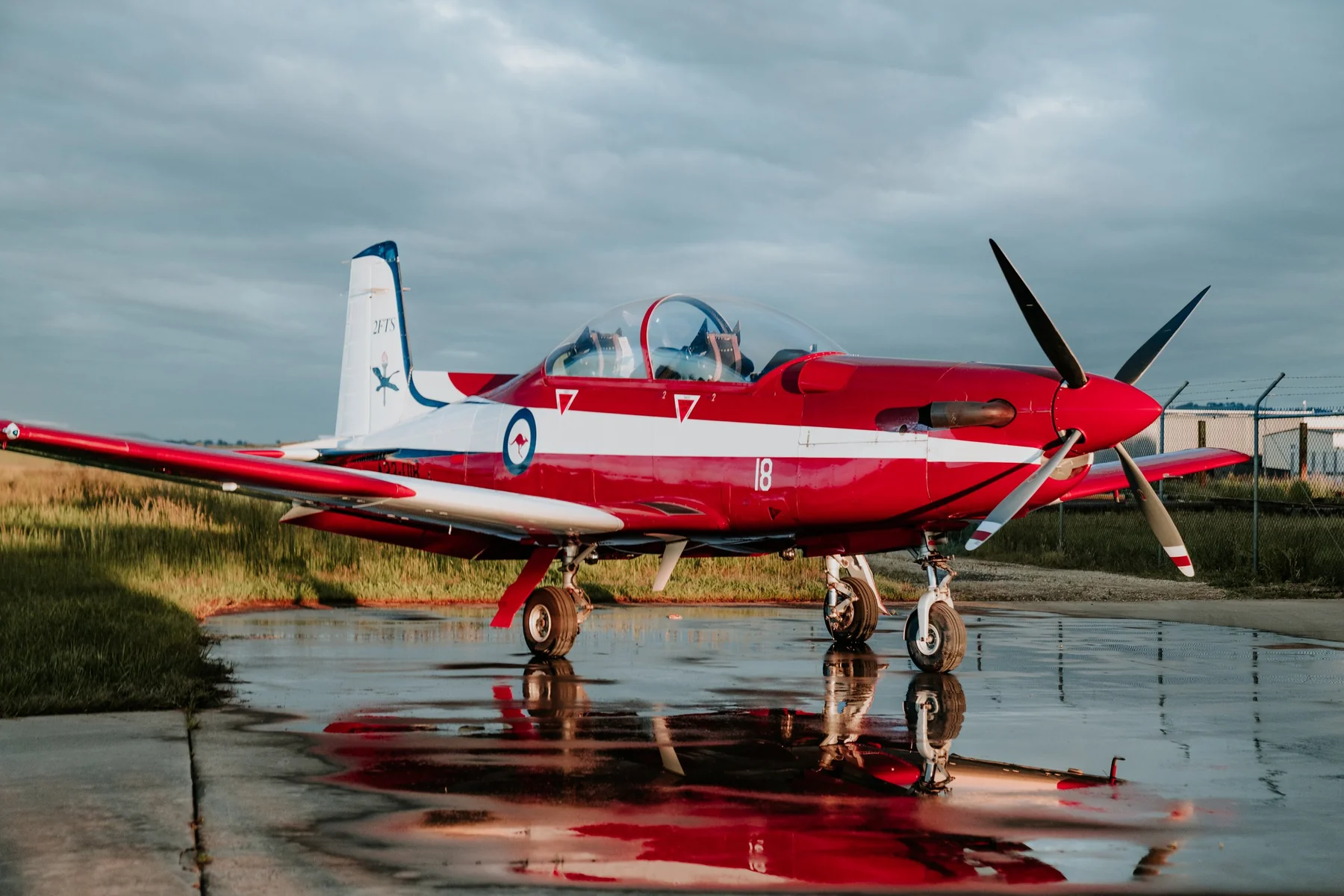 Red and white PC-9 aircraft on the apron